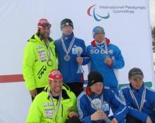 A picture of a men in a podium showing their trophies