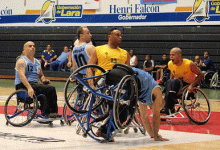 A picture of a men in wheelchairs playing basketball