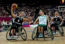 A picture of two women in wheelchairs playing basketball