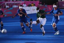 A picture of a blind person shooting the ball in a football match