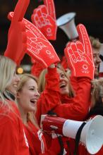 A picture of girl with a big glove with "Apply Now" written on it.