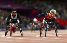 A picture of a woman in the wheelchair celebrating the victory with her hand up