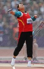 A picture of a woman on the field throwing the discus