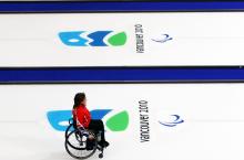 A picture of a woman in a wheelchair playing curling