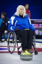 A picture of a woman in a wheelchair playing curling