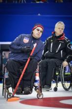 A picture of a man in a wheelchair playing curling