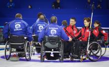 A picture of person in wheelchairs shaking their hands