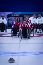 A picture of person in wheelchairs playing curling