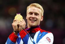 A picture of a man holding his medal with bouth hands