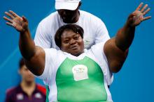 A picture of a woman powerlifter on a bench celebrating with her hands up