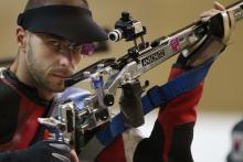 A picture of a man posing with his rifle at the shooting competition