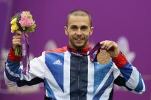 A picture of a man on a podium with a medal around his neck