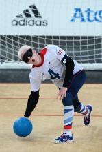 A picture of a blind man launching a ball