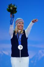 French snowboader Cecile Hernandez-Cervellon points to the crowd at the Sochi 2014 victory ceremony while wearing her silver medal.