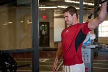 An athlete works out his shoulders in the gym.