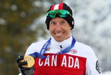 Upper body of smiling man holding medal