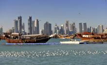 Wooden boat in the water, skyscrapers in the background
