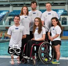 Group shot of six swimmers in front of a pool