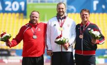 Podium with three men showing their medals