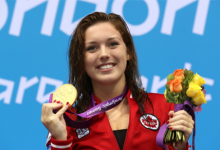 A picture of woman showing her gold medal