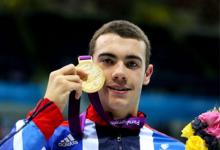 A portrait of man showing his gold medal