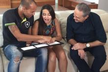 A blind girl feels a 3D model with her hands while her father looks on 