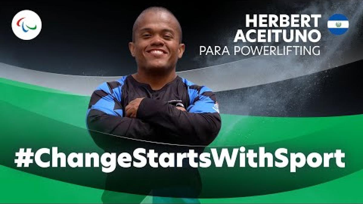 Thumbnail of a video about Para powerlifting athlete Herbert Aceituno. The image features him smiling with his arms crossed.